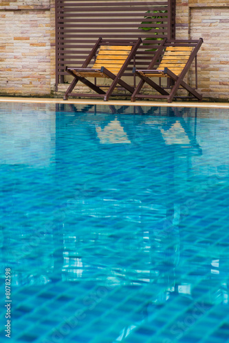 Chair on ground beside swimming pool