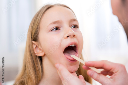Young little girl being examinated by a doctor photo