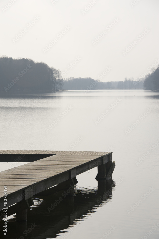 Wooden pier on a Polish lake on an early spring morning