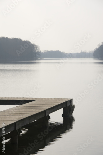 Wooden pier on a Polish lake on an early spring morning © tom asz