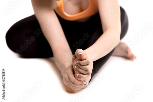 Female athlete holding sore foot, close up of female legs