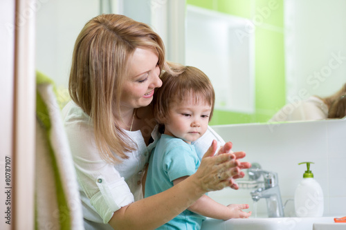 child boy washing hands with soap in bathroom
