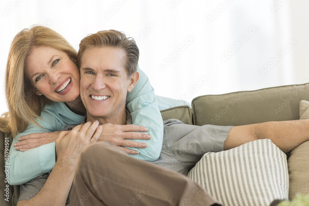 Happy Woman Embracing Man On Sofa At Home Happy Woman Embracing Man On Sofa At Home