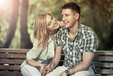 Relatioship concept. Happy young couple sitting in the park, smi