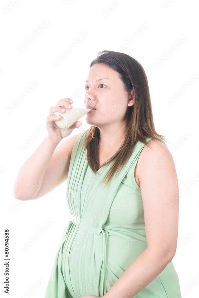Pregnant Woman holding her pregnant belly and get a glass of mil Pregnant Woman holding her pregnant belly and get a glass of mil