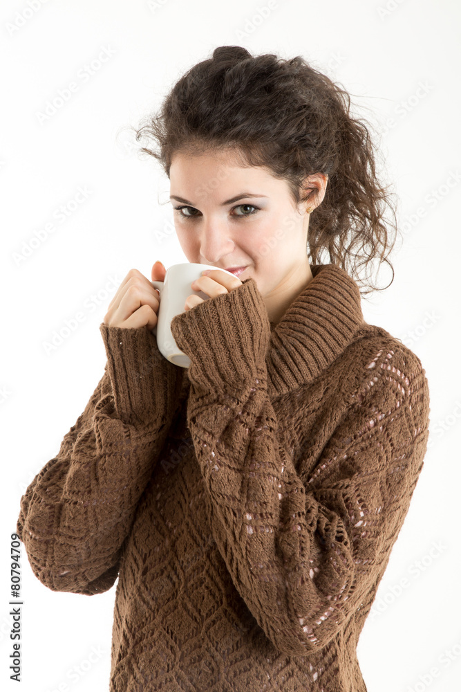 Brunette in knitted pullver drinking from a mug Brunette in knitted pullver drinking from a mug