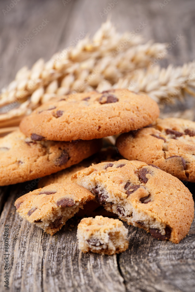 Tasty cookies with wheat on a wooden table.