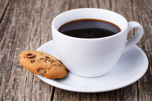 Cup of coffee with cookies on a wooden table.