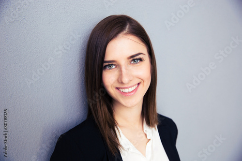 Smiling businesswoman over gray background
