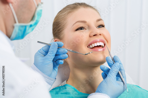 Male doctor doing dental treatment in clinic. Teeth repair.