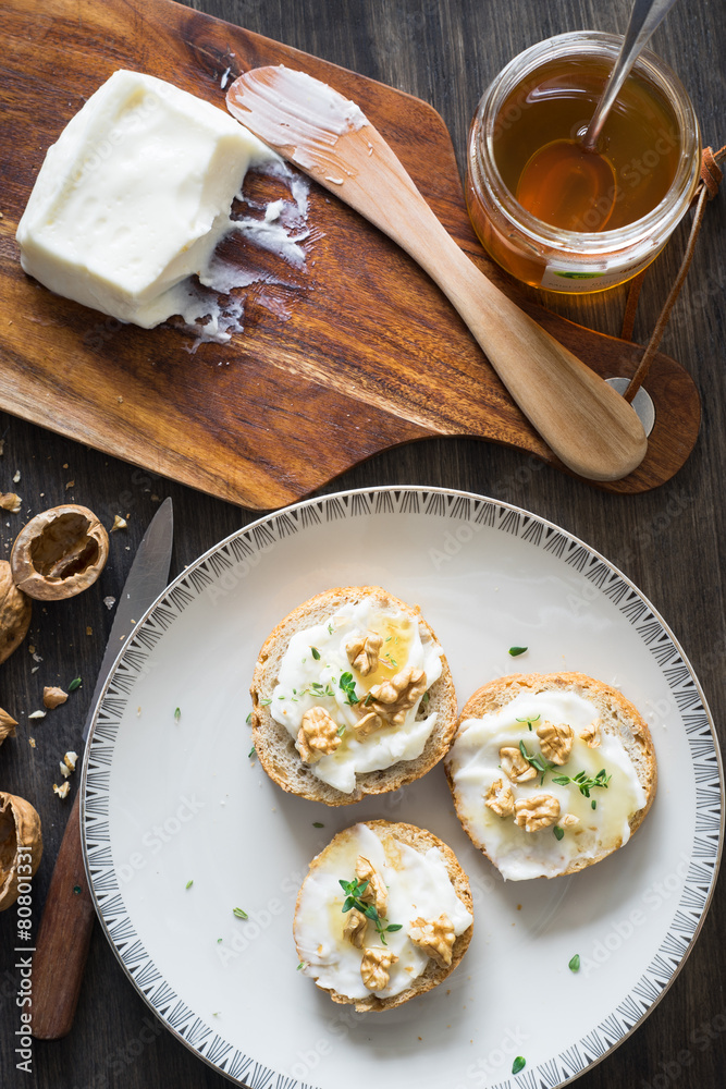 Fototapeta Bruschette with Stracchino Cheese, Honey, Walnuts and Thyme