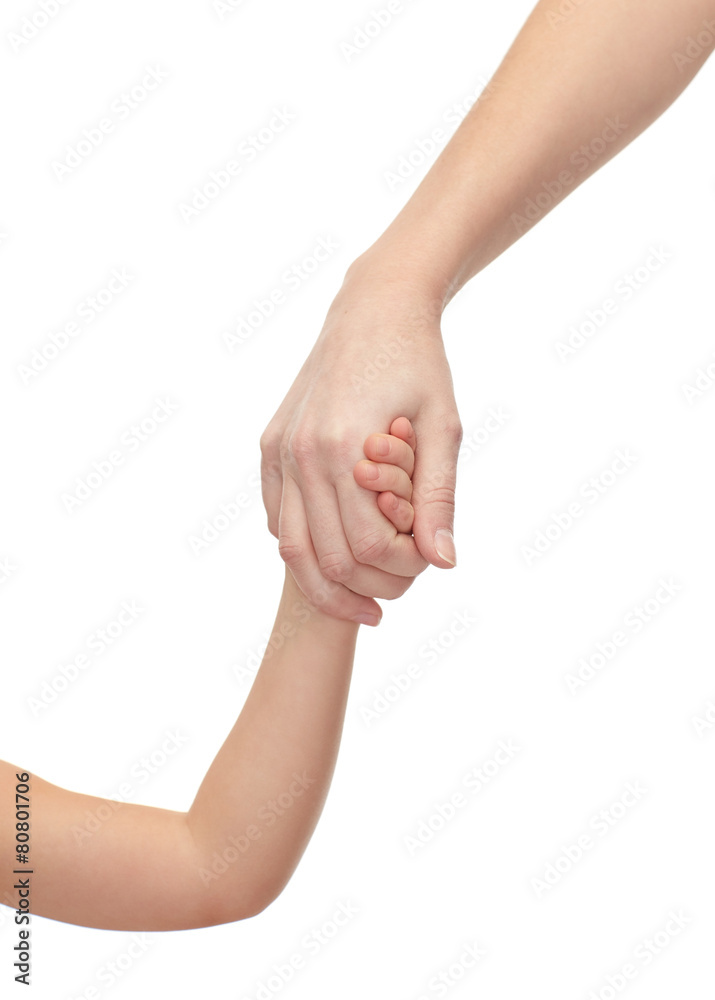 close up of woman and little girl holding hands close up of woman and little girl holding hands