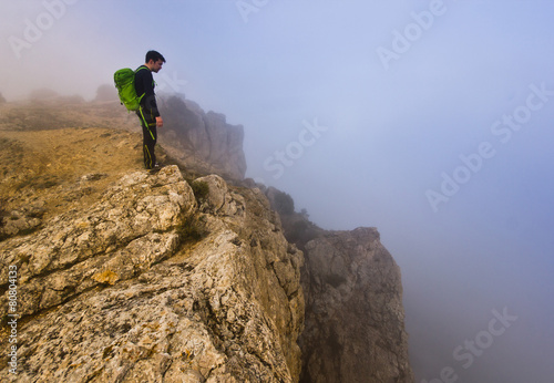 man standing on a cliff in foggy weather