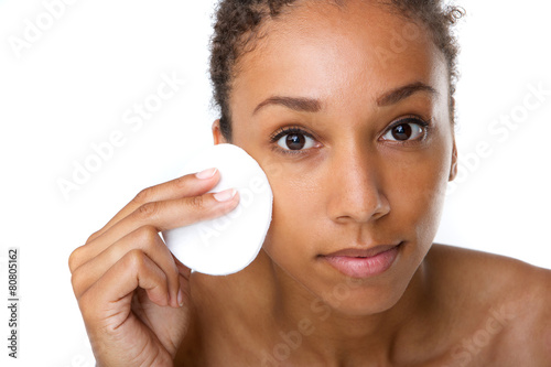 African american woman removing makeup with sponge