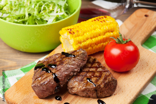 Steak with grilled corn, salad and red wine