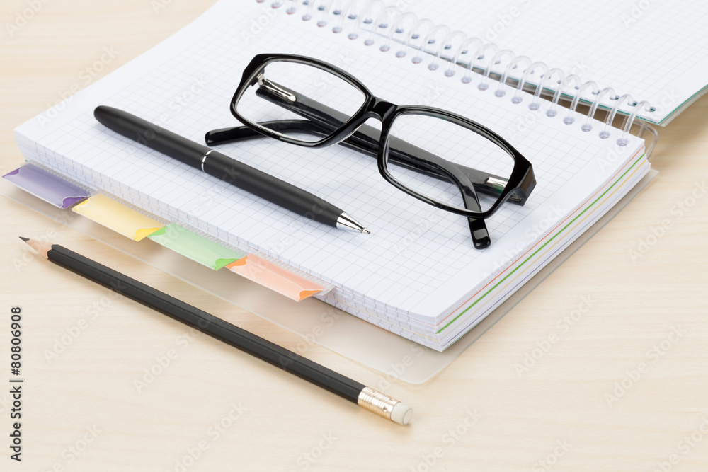 Office table with glasses, blank notepad and pencil Office table with glasses, blank notepad and pencil