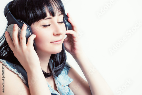 Красивая девушка в наушниках слушает приятную музыку.