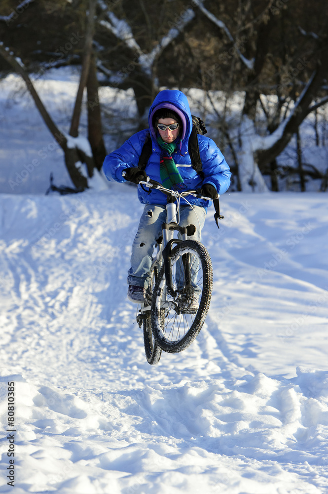 Jumping cyclist extreme riding mountain bike in snow Jumping cyclist extreme riding mountain bike in snow
