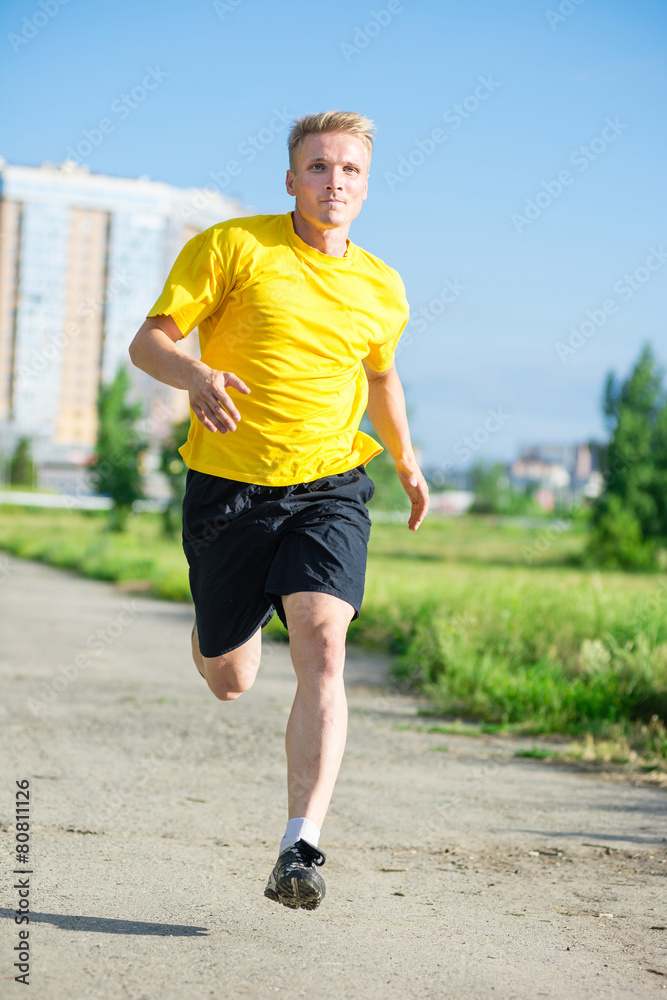 Sporty man jogging in city street park. Outdoor fitness. Sporty man jogging in city street park. Outdoor fitness.