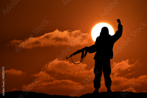 Silhouette of soldier officer with weapons at sunset