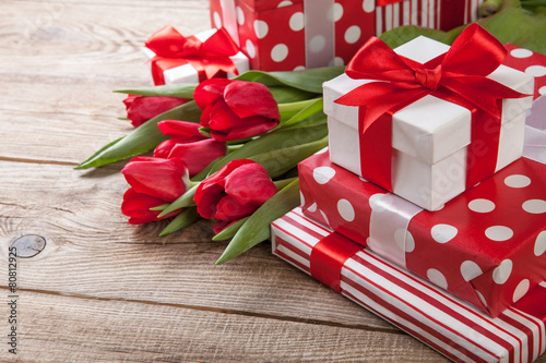 Fototapeta Naklejka Na Ścianę i Meble -  bouquet of tulips and gift boxes on the board