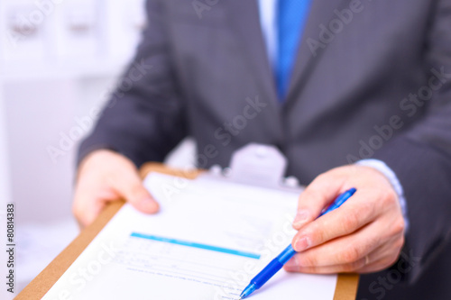 Schilderij op canvas Businessman holding a blank white board
