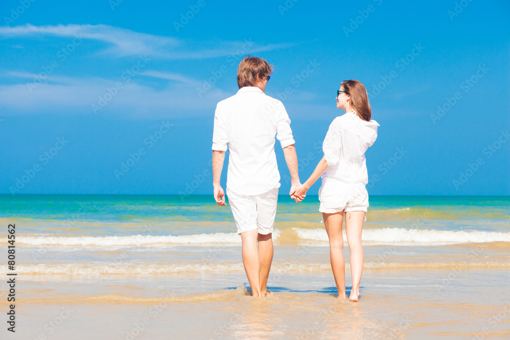 happy young couple in white clothes having fun on tropical beach happy young couple in white clothes having fun on tropical beach