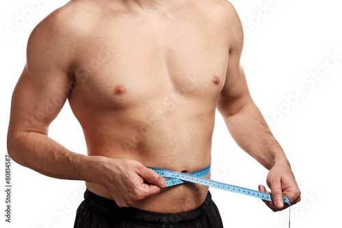 Male torso with measure tape on waistline