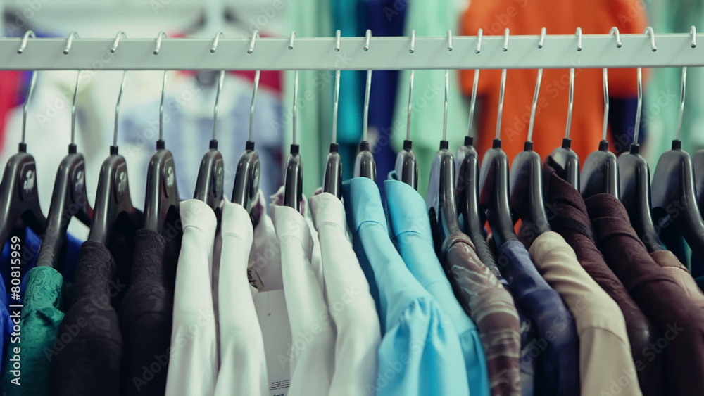 DOLLY MOTION: Variety of clothes hanging on rack in boutique