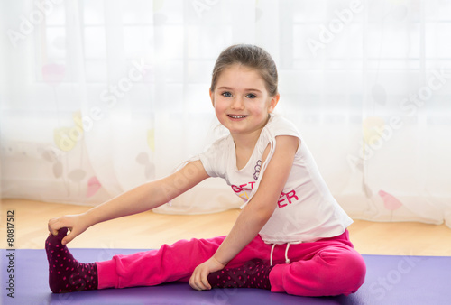 Child doing sport exercises at home