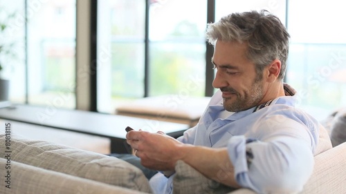 Mature man sending message with smartphone