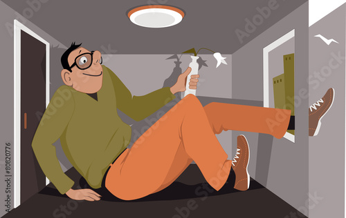 Happy man squeezed into a tiny apartment