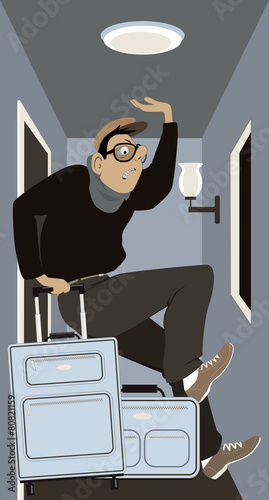 Man with luggage checking into a small hotel room