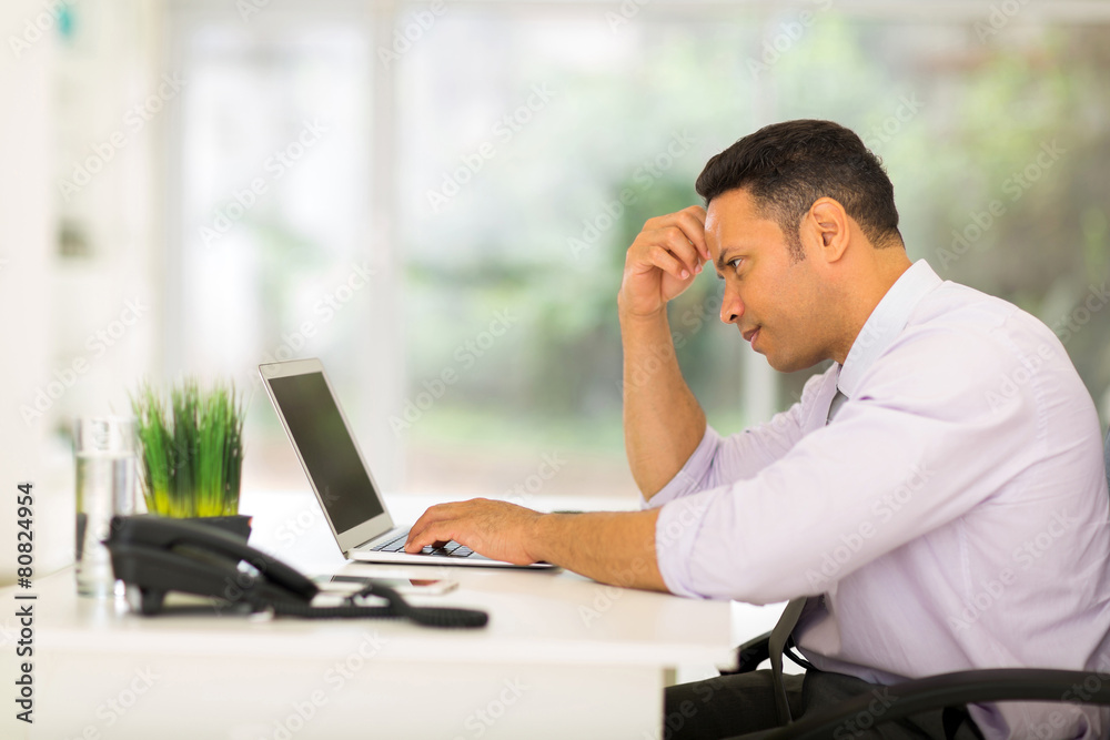 middle aged businessman looking at computer screen