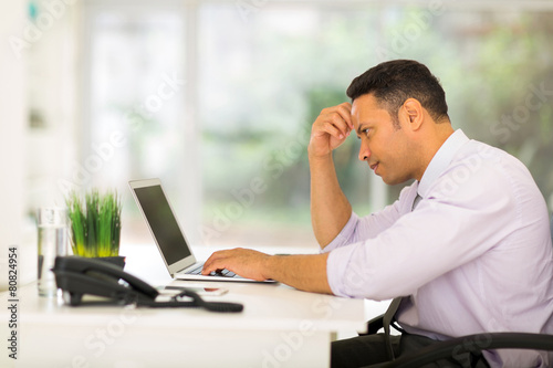 middle aged businessman looking at computer screen