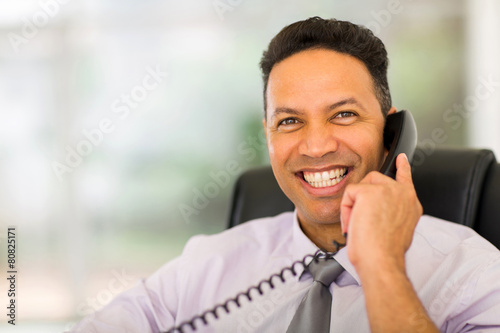 mid age businessman using landline phone