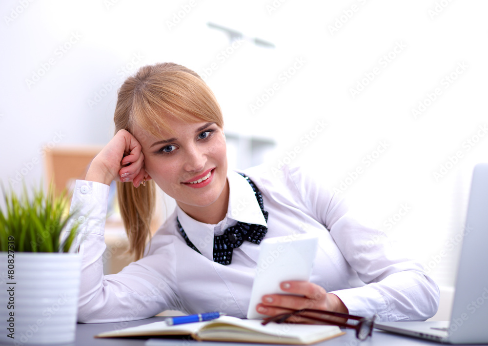 Portrait of businesswoman sitting at desk with a laptop Portrait of businesswoman sitting at desk with a laptop