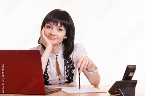 Call-center employee at a desk with pen in hand photo