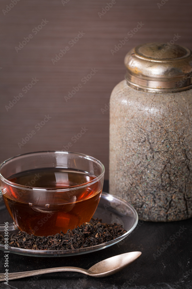 dry tea leaves in glass cup of tea and vintage jar dry tea leaves in glass cup of tea and vintage jar