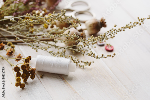 Sewing kit with flowers on a wooden background