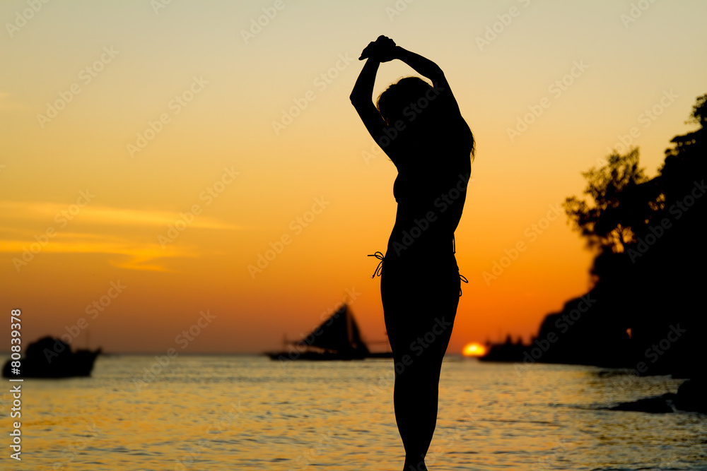 silhouette of young beautiful woman on tropical sunset sea backg silhouette of young beautiful woman on tropical sunset sea backg
