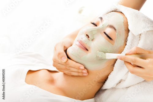 Young beautiful woman with clay facial mask