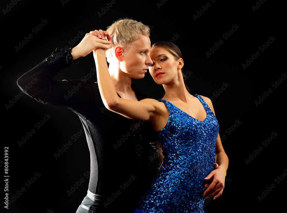 Beautiful couple of professional artists dancing on black background