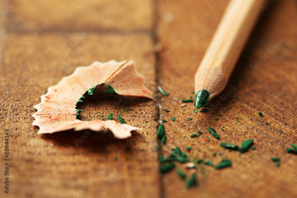 Wooden color pencil with sharpening shavings on wooden table Wooden color pencil with sharpening shavings on wooden table