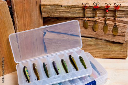 Fishing baits on wooden background.