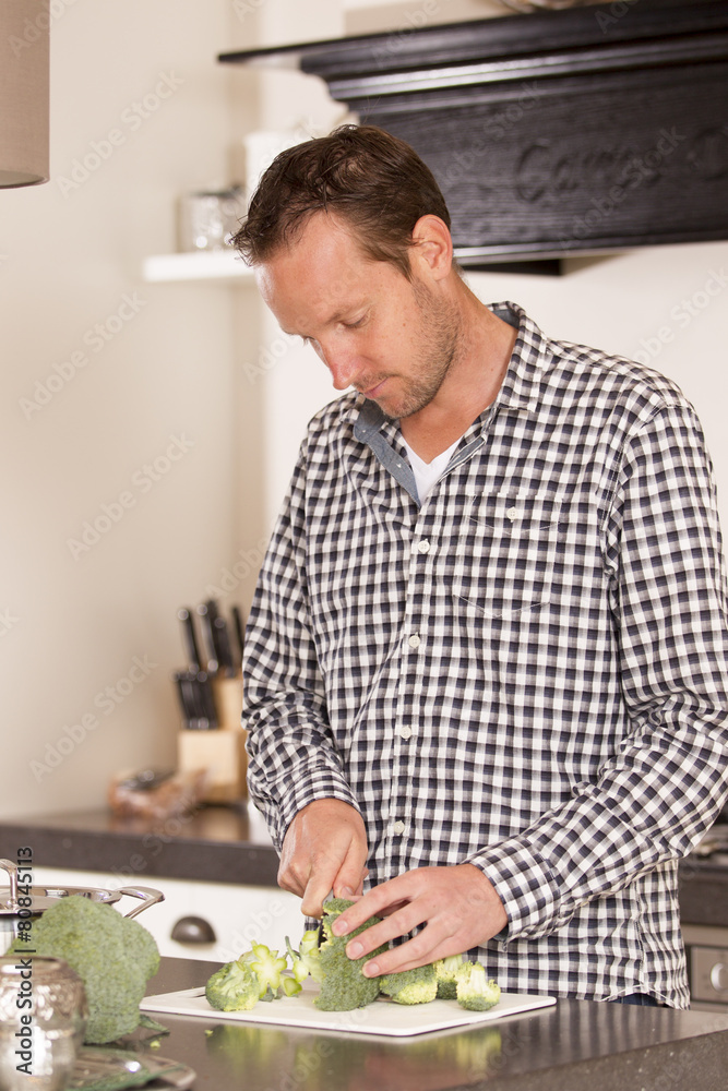 Young male cook cooking in his own kitchen at home Young male cook cooking in his own kitchen at home