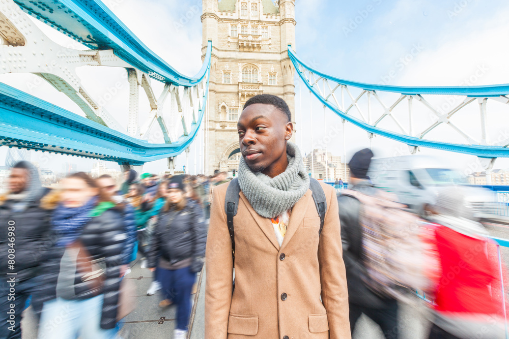 Fototapeta premium Man on Tower Bridge, London, with blurred people on background