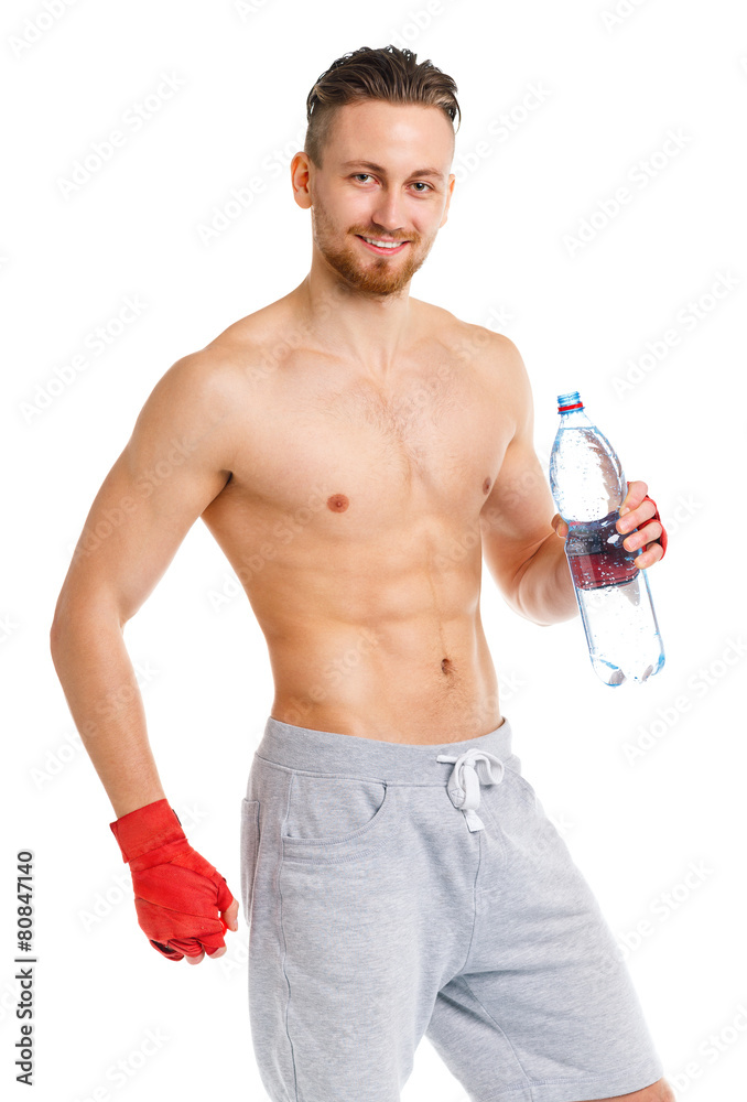 Athletic attractive man wearing boxing bandages with bottle of w