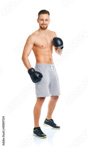 Athletic attractive man wearing boxing gloves on the white