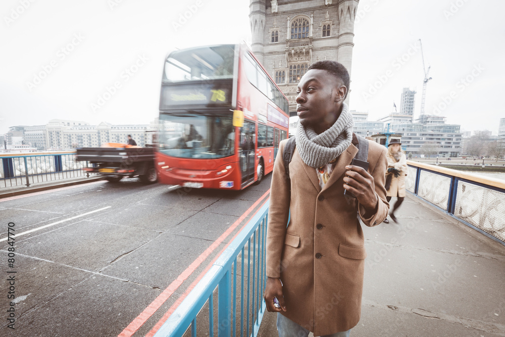 Young black man in London walking  on Tower Bridge